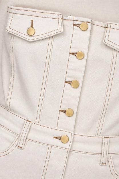 Close-up detail of white denim dress button placket and topstitching