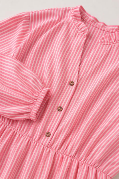 Close-up detail of buttons, collar, and fabric texture on pink striped dress