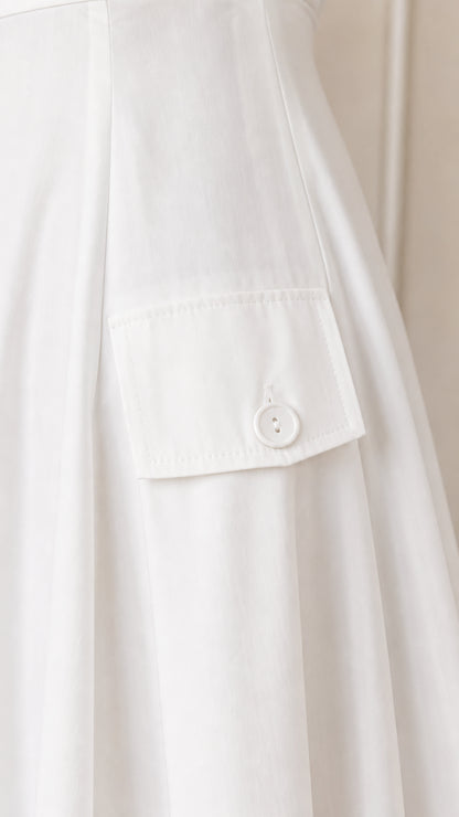 Close-up detail of pocket and button on white dress
