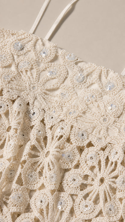 Close-up detail of the floral crochet pattern and subtle embellishments on the ivory top