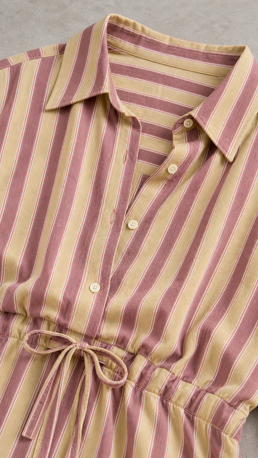Close-up detail of lapel collar and drawstring waist on khaki striped set