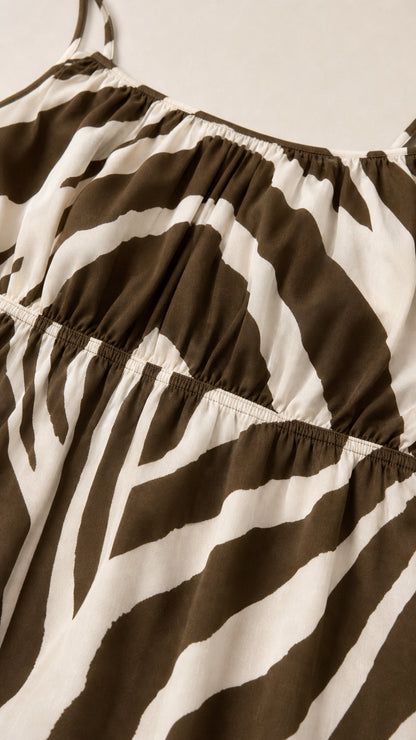 Close-up detail of smocked bodice on brown zebra print dress
