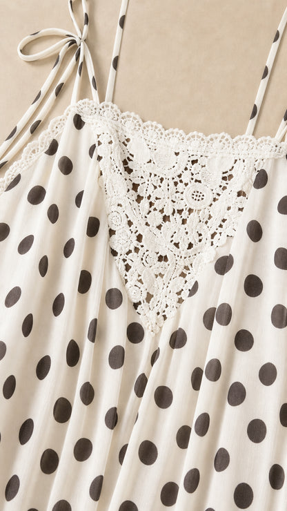 Close-up detail of lace trim and polka dot pattern on white dress