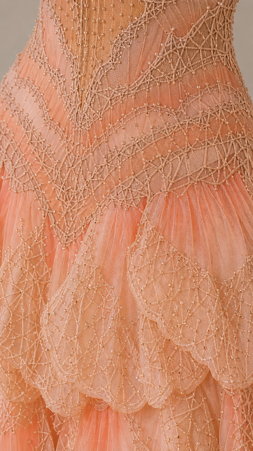Close-up detail of intricate beadwork and ruffle tiers