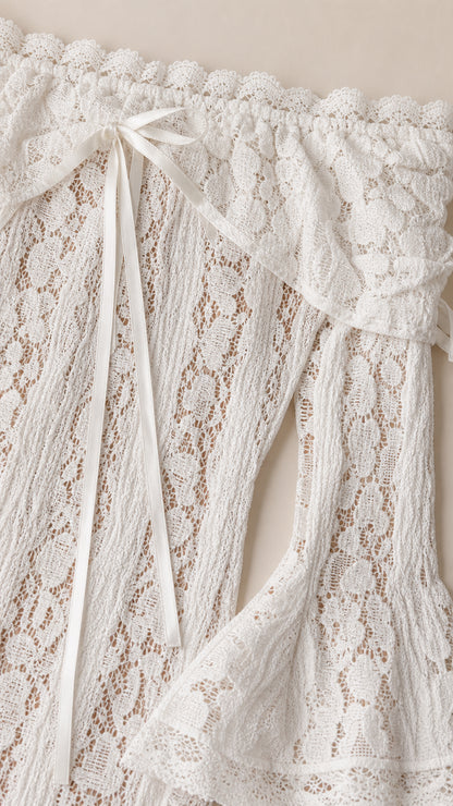 Close-up detail of the white lace fabric, neckline, and bow tie accents