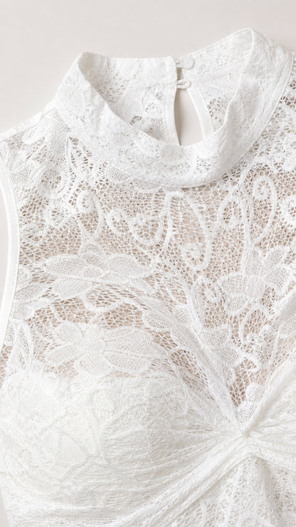 Close-up detail of white lace fabric and halter neckline