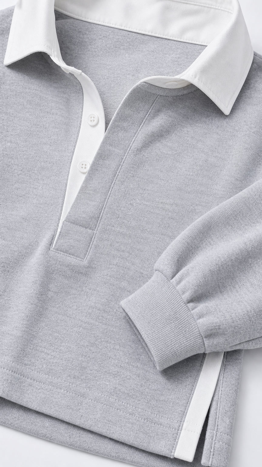 Close-up detail of light grey polo collar and ribbed cuff