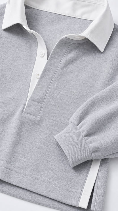 Close-up detail of light grey polo collar and ribbed cuff