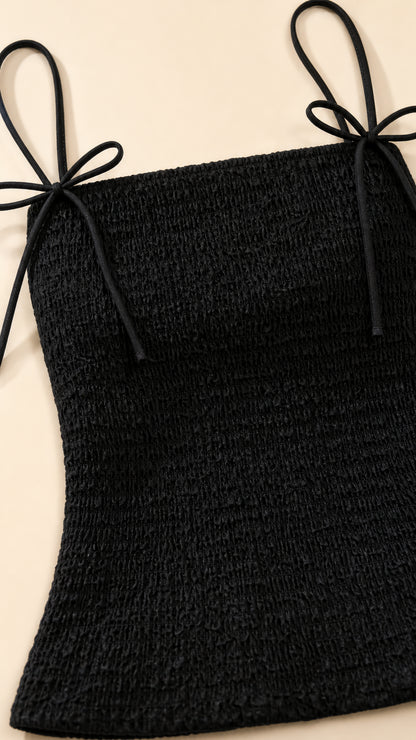 Close-up of black smocked top with tie straps