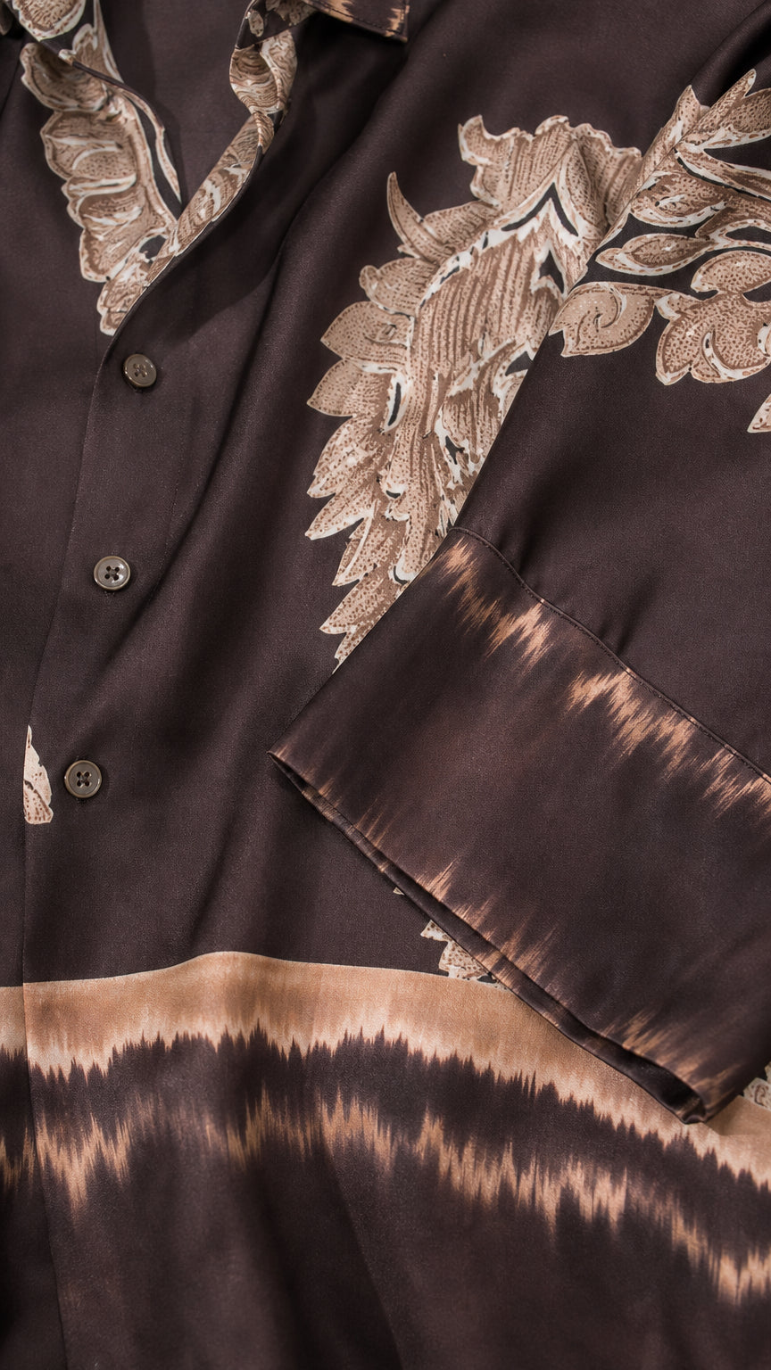 Close-up detail of smooth satin fabric, buttons, and paisley border print