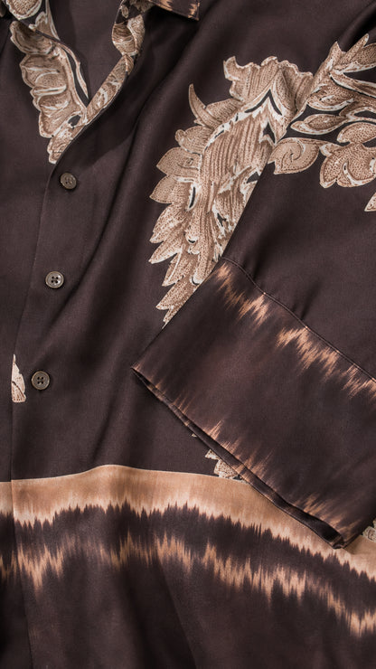 Close-up detail of smooth satin fabric, buttons, and paisley border print