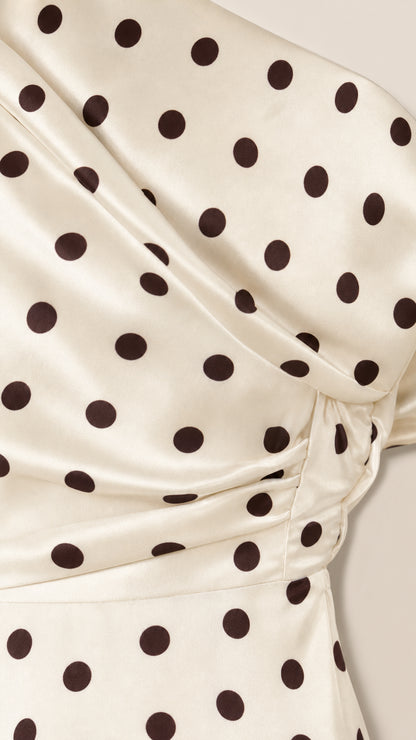 Close-up detail of cream and black polka dot fabric and drape