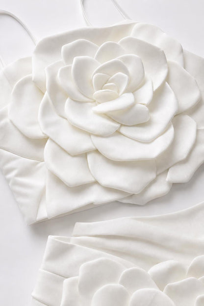 Close-up flat lay detail of white 3D fabric rose appliqué on top and skirt