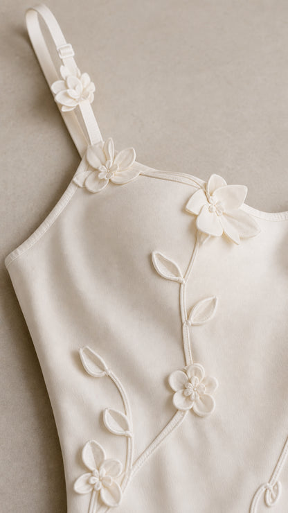 Close-up detail of 3D floral appliques on camisole strap and bodice