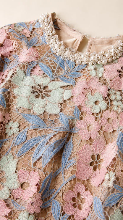 Close-up detail of pearl-embellished neckline and floral lace pattern