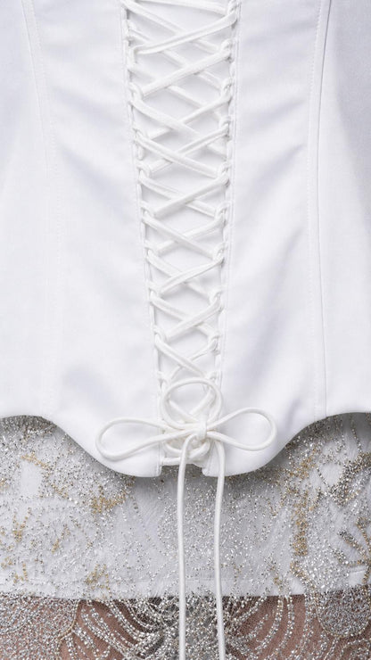 Close-up detail of white lace-up corset back and lace skirt hem