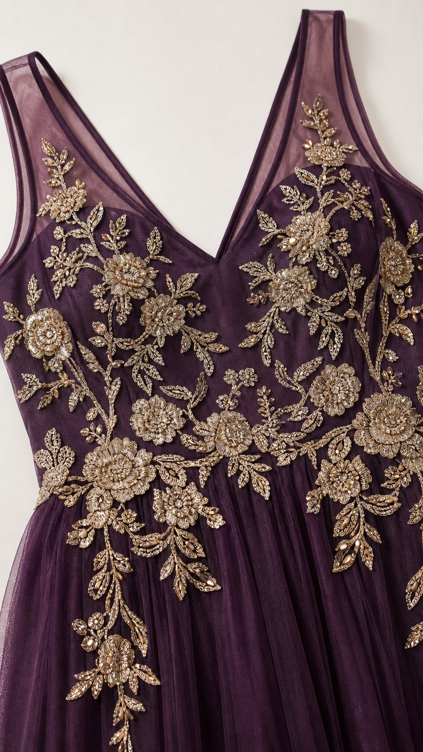 Close-up detail of gold floral embroidery on purple bodice