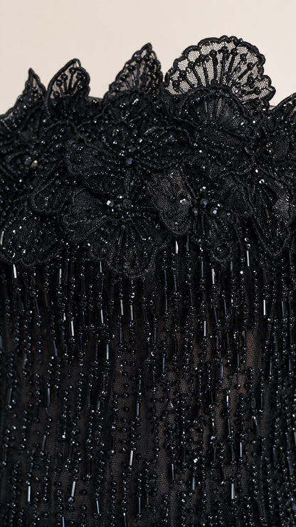 Close-up detail of 3D floral beaded neckline on black gown