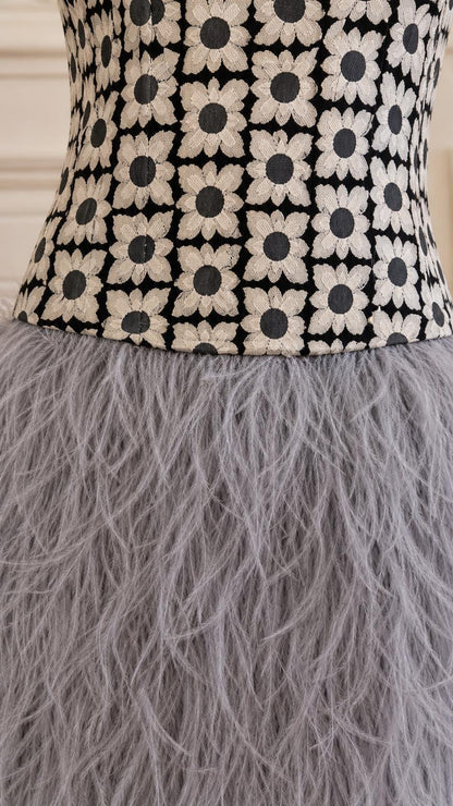 Close-up detail of the floral embroidered bodice and feather skirt