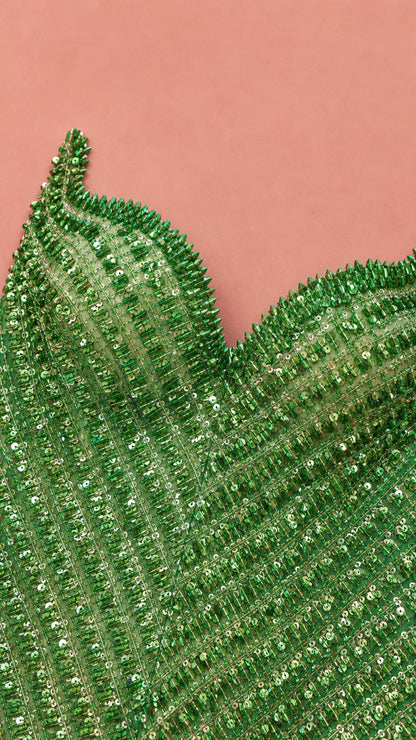 Close-up detail of sweetheart neckline and vertical green beadwork