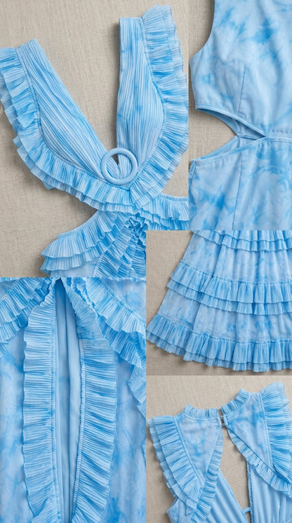 Close-up details of fabric, ruffles, and ring accent on light blue dress