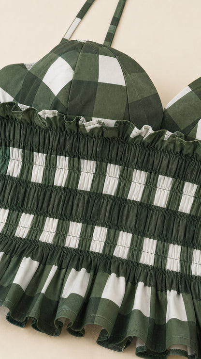 Close up of green gingham smocked bodice and straps