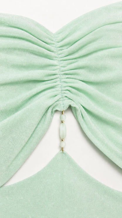 Close-up of ruched bodice and beaded detail on mint green dress
