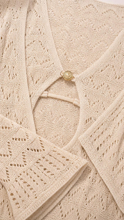 Close-up detail of neckline, ring accent, and knit pattern on beige dress