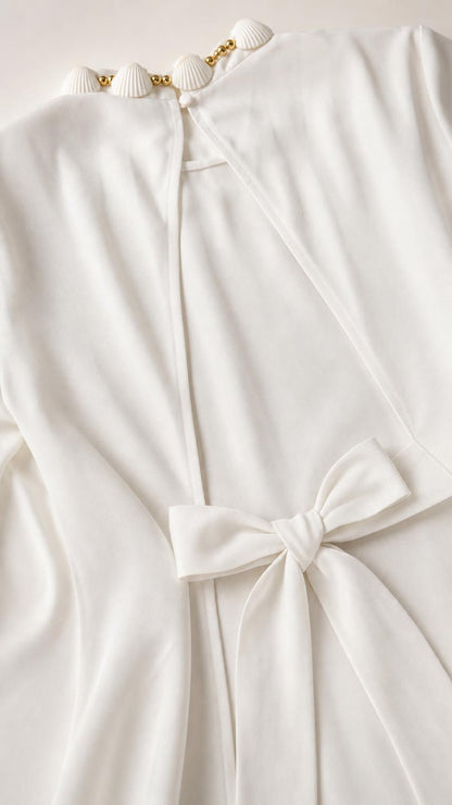 Close-up detail of seashell neckline and back bow