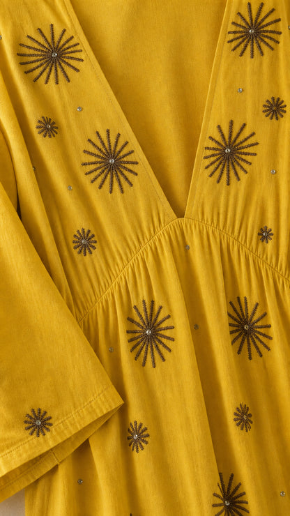 Close-up detail of V-neck and starburst embroidery