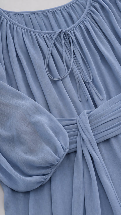 Close-up detail of neckline and pleated waist tie on blue midi dress