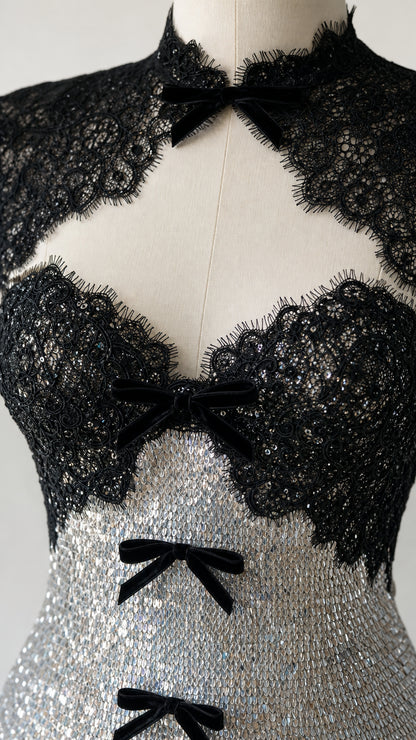 Closeup of black lace bodice, mock neck, and bow details