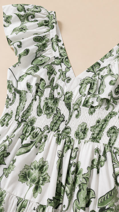 Close up of ruffle shoulder and smocked bodice detail on white floral dress