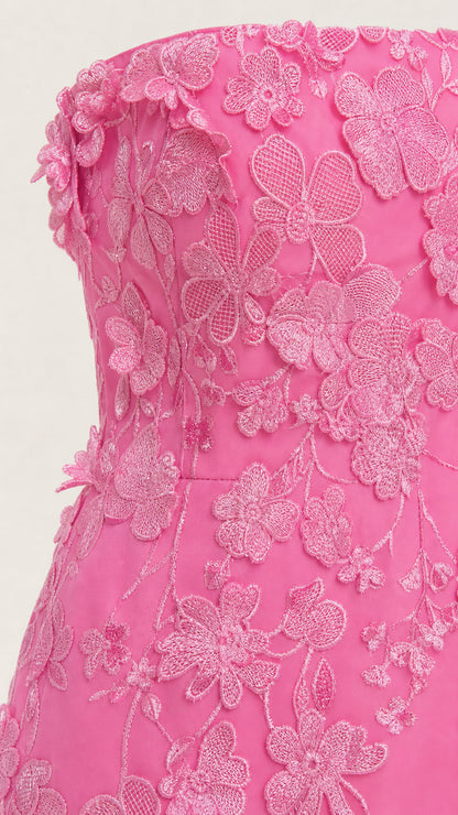 Close-up detail of textured floral appliques on pink bodice