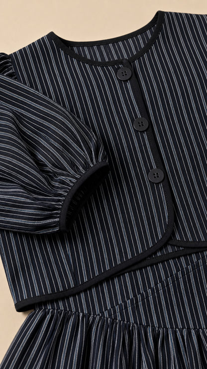Close-up detail of black pinstripe crop top buttons and puff sleeves