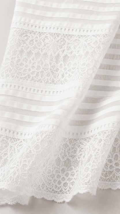 Close-up detail of white lace and striped fabric texture