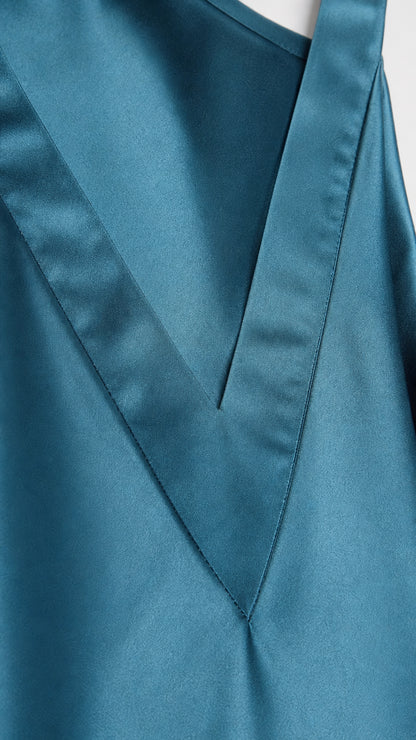 Close-up detail of V-neckline and fabric texture on teal satin dress
