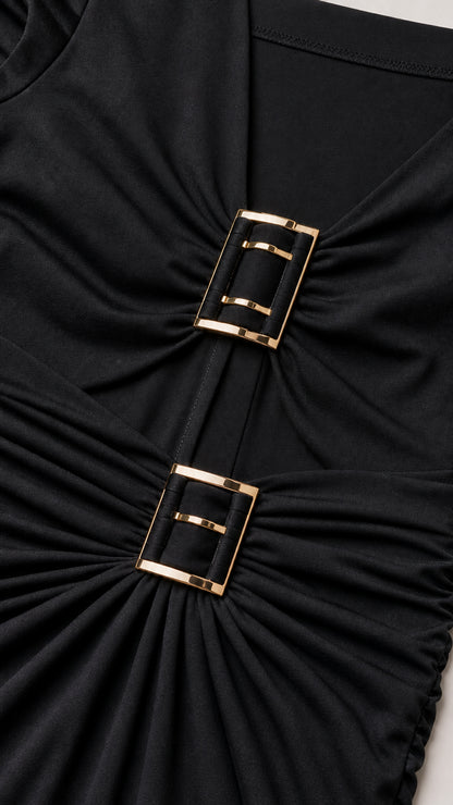 Close-up of metallic buckle accents on black dress bodice