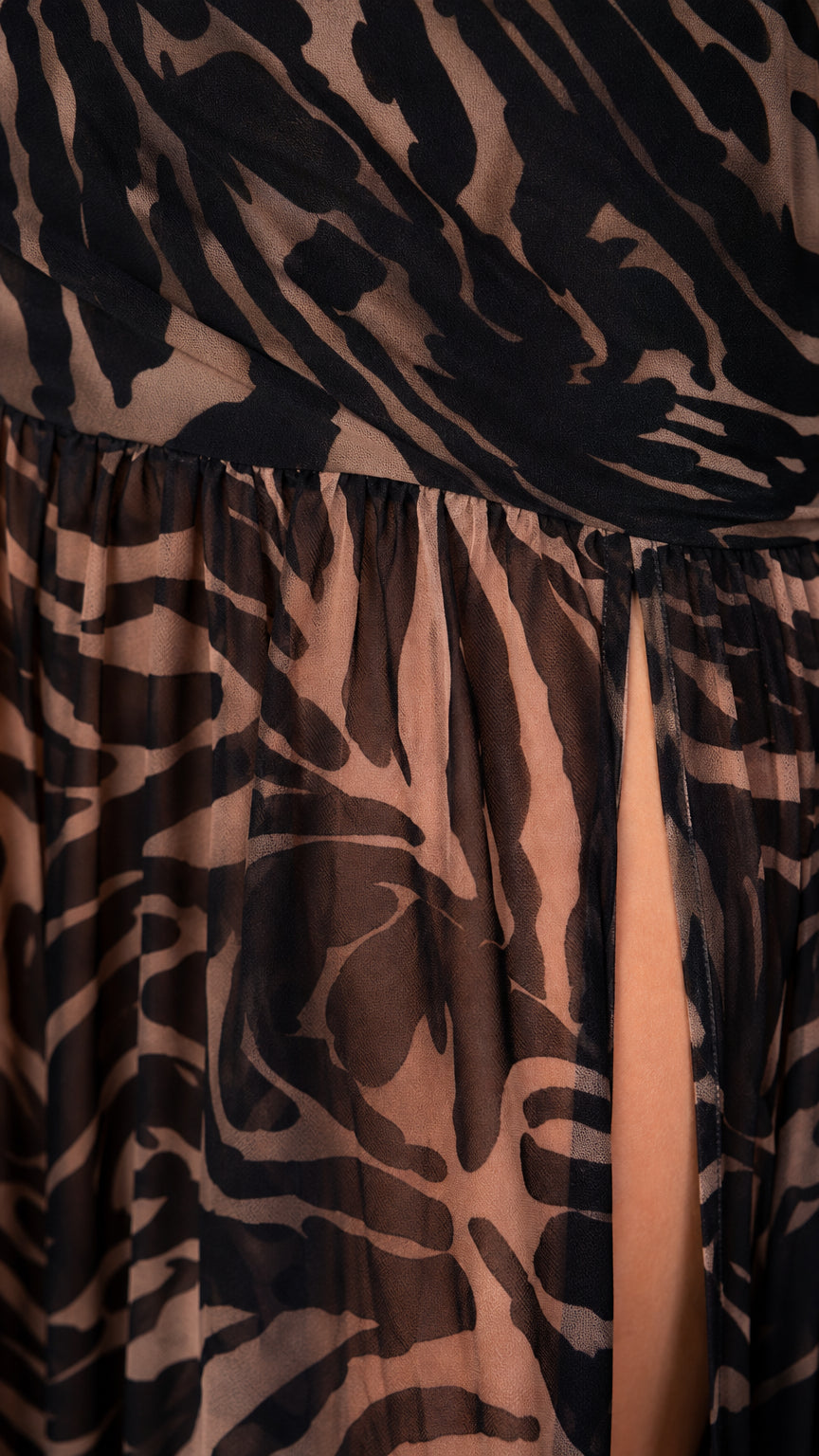 Close-up detail of fabric texture and high slit on zebra print maxi dress