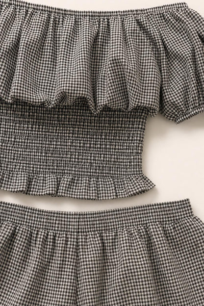 Close-up detail of the black and white gingham fabric, smocked bodice, and ruffle trim
