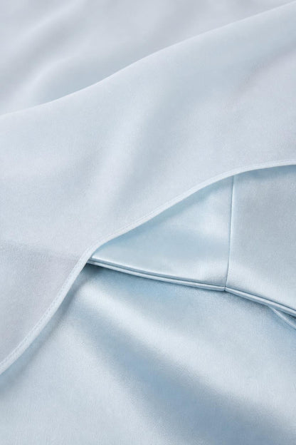 Close-up of light blue satin fabric and sheer overlay texture