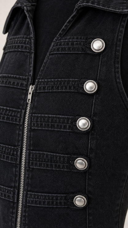 Close-up detail of silver buttons and zipper on black denim vest