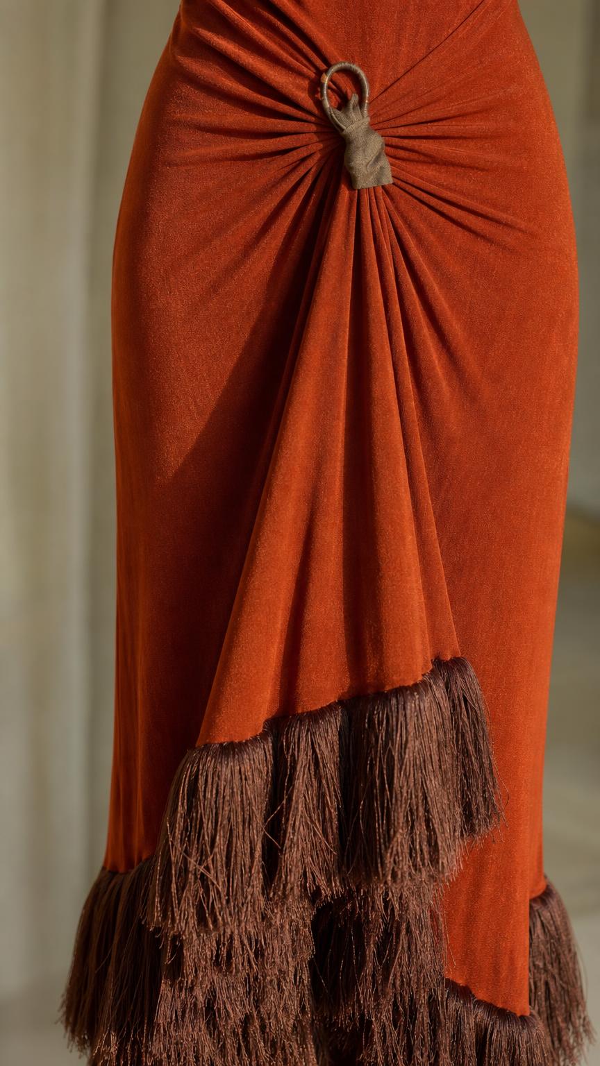 Close up of ring detail and fringe hem on rust maxi dress