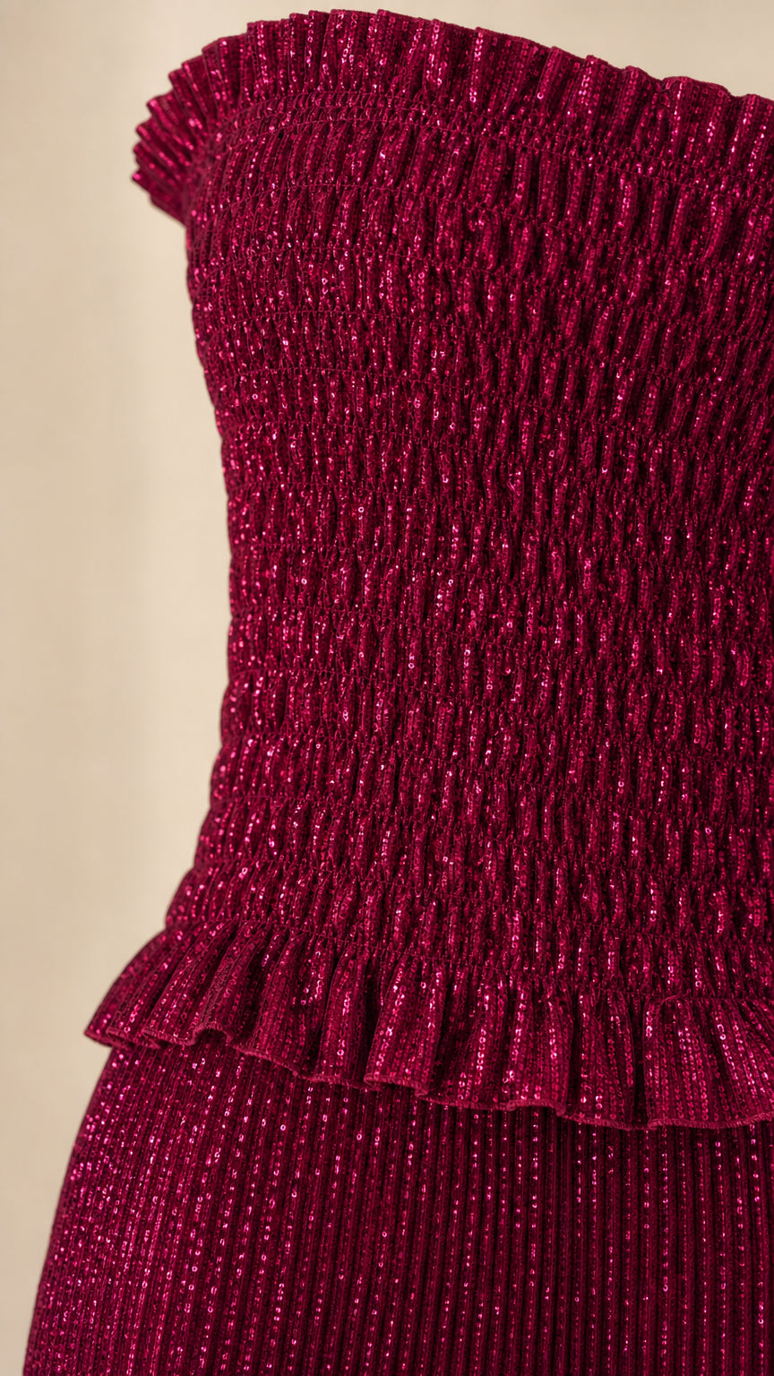 Close-up of the burgundy pleated textured fabric and ruched lower bodice