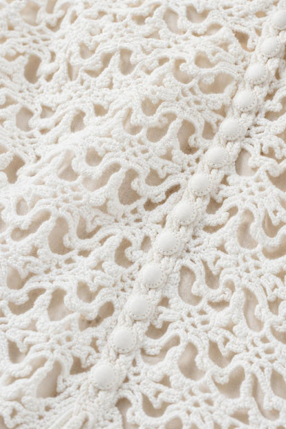 Close-up detail of white crochet lace fabric and buttons
