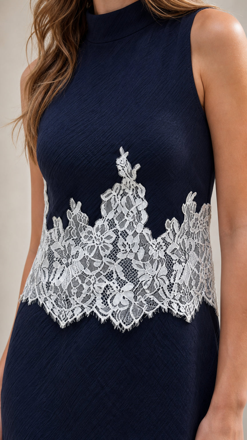 Close up of mock neckline and waist lace detail on navy dress