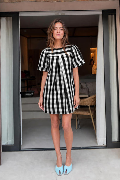 Front view of woman wearing black gingham check mini dress