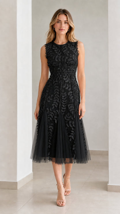 Front view of model wearing black embroidered leaf applique midi dress