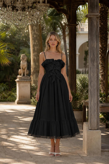 Front view of woman wearing black bow accent midi dress