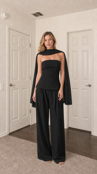 Front view of model wearing black strapless top, wide-leg pants, and scarf